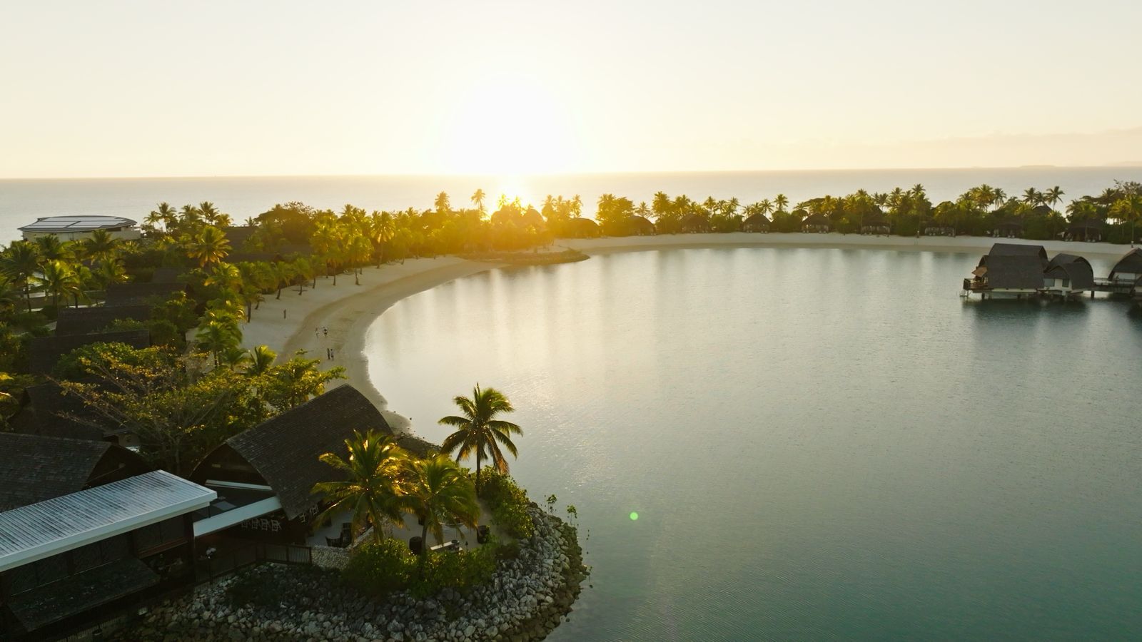 Aerial view of a resort lagoon and beach at sunset in Fiji