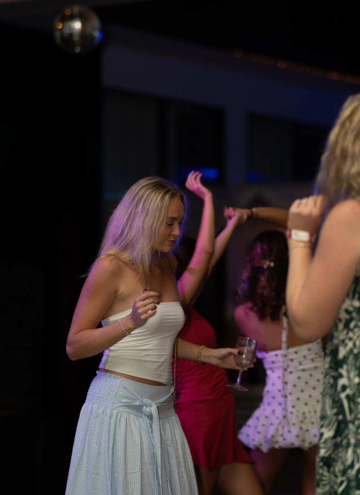 Woman dancing in pink light at a party