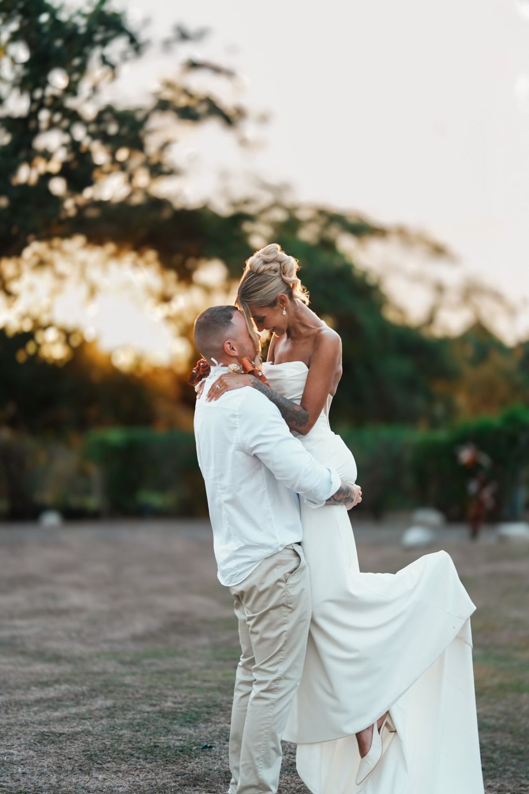 Groom lifting his bride at golden hour